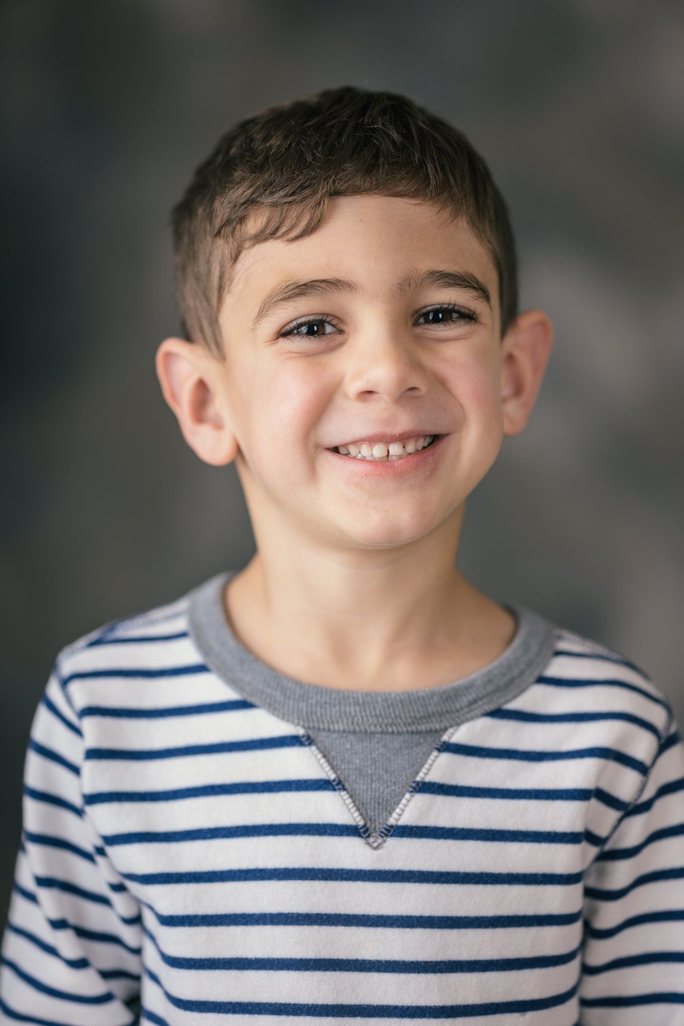 Portrait series showing expressions in striped shirt against dark background.