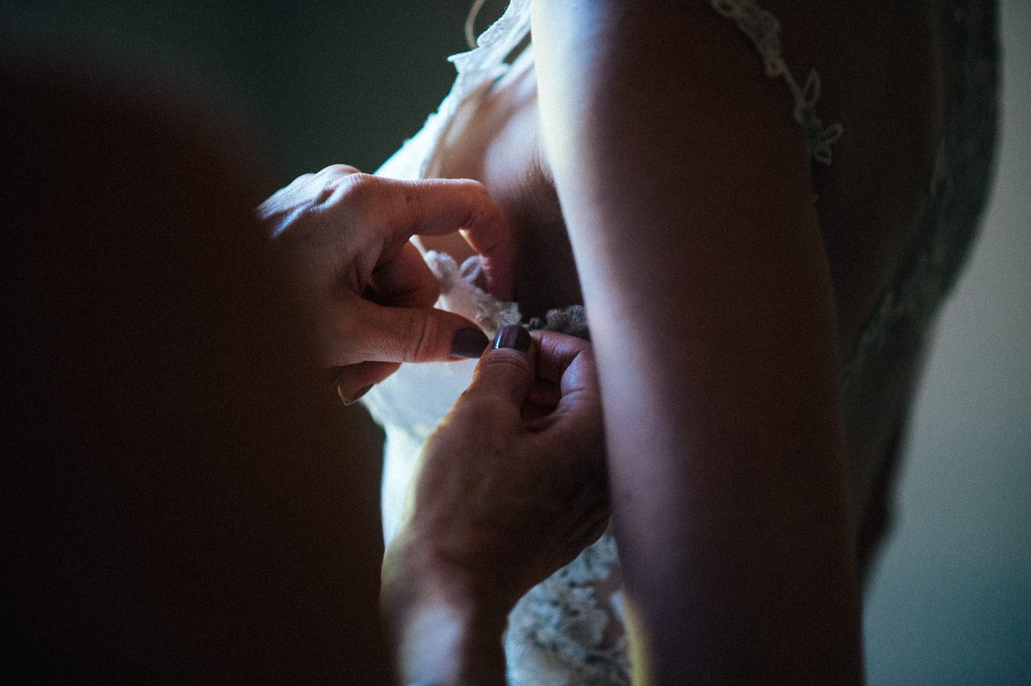 Close-up detail shot of wedding preparation in dramatic lighting.
