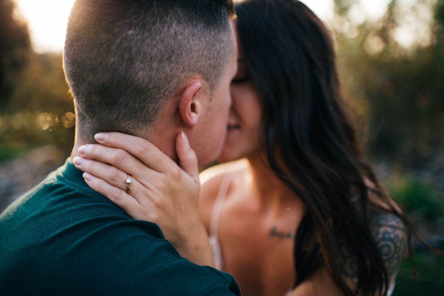 A close-up shot of an intimate moment between a couple in golden hour light.