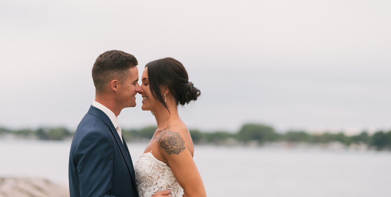 Intimate waterfront wedding ceremony moment with overcast sky.