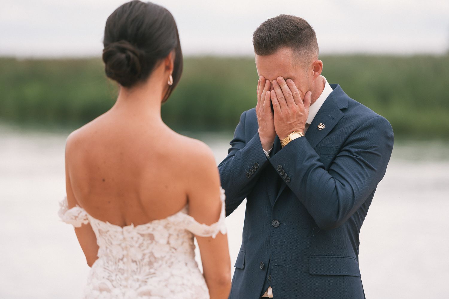 First look wedding moment captured by water with emotional reactions.