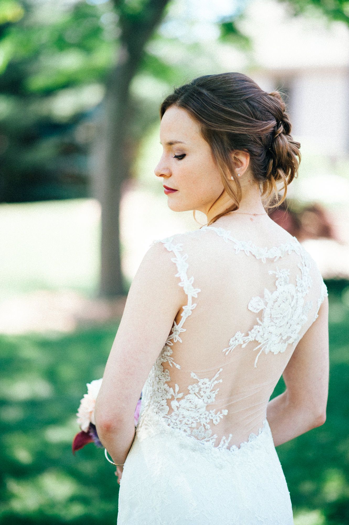Close-up details of a bride's lace wedding dress back with delicate floral patterns.