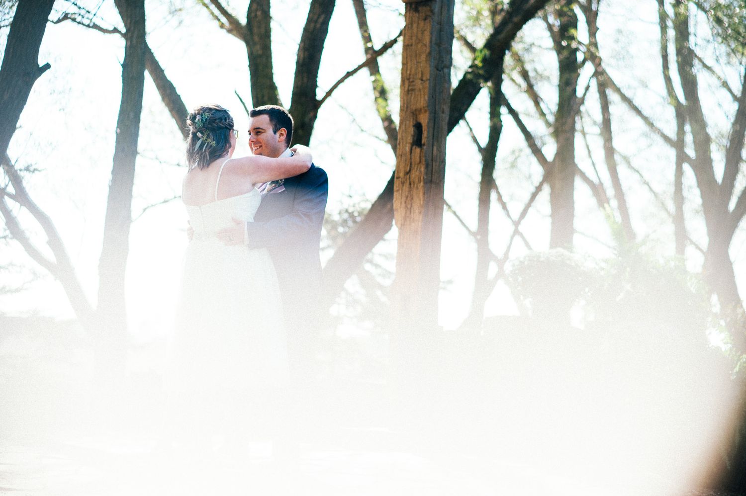 Artistic silhouette of a couple embracing in sunlit woods.
