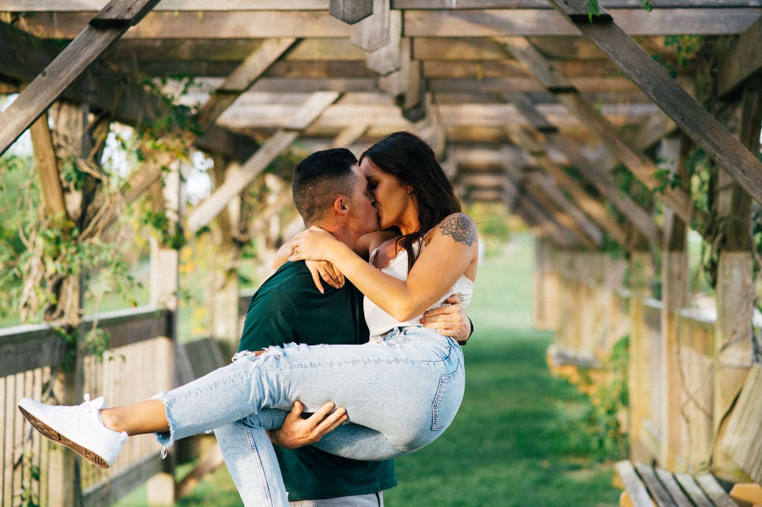 Romantic sequence under wooden pergola with couple embracing in garden setting.