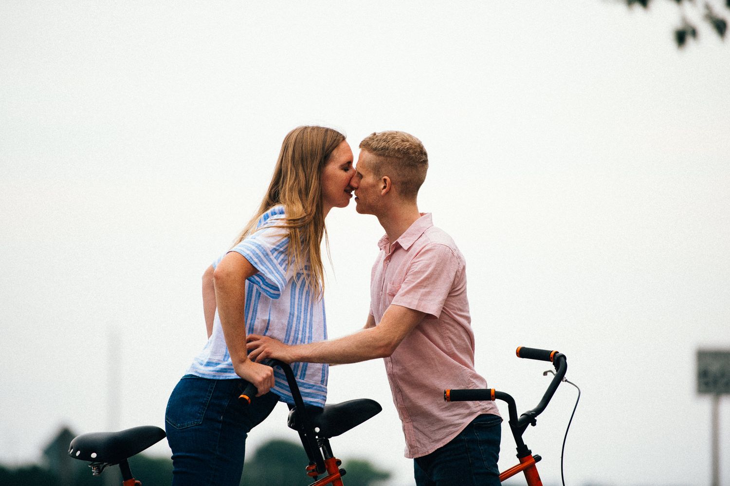 Intimate couple's portrait session with vintage bicycle in minimalist white setting.