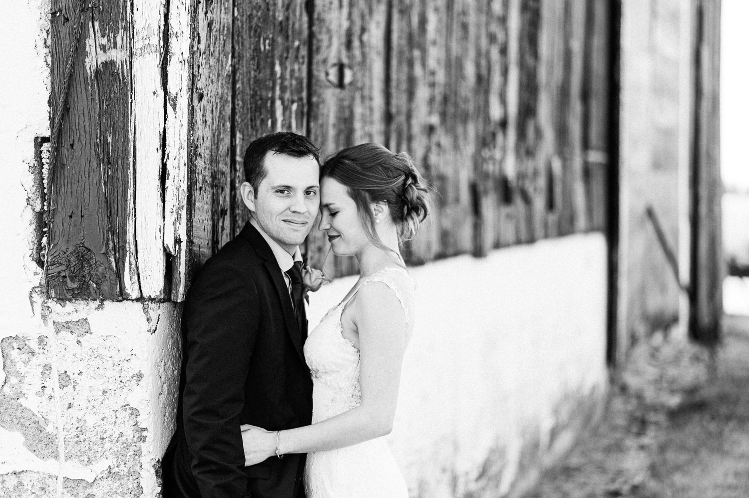 A romantic black and white portrait series against a rustic wooden wall backdrop.