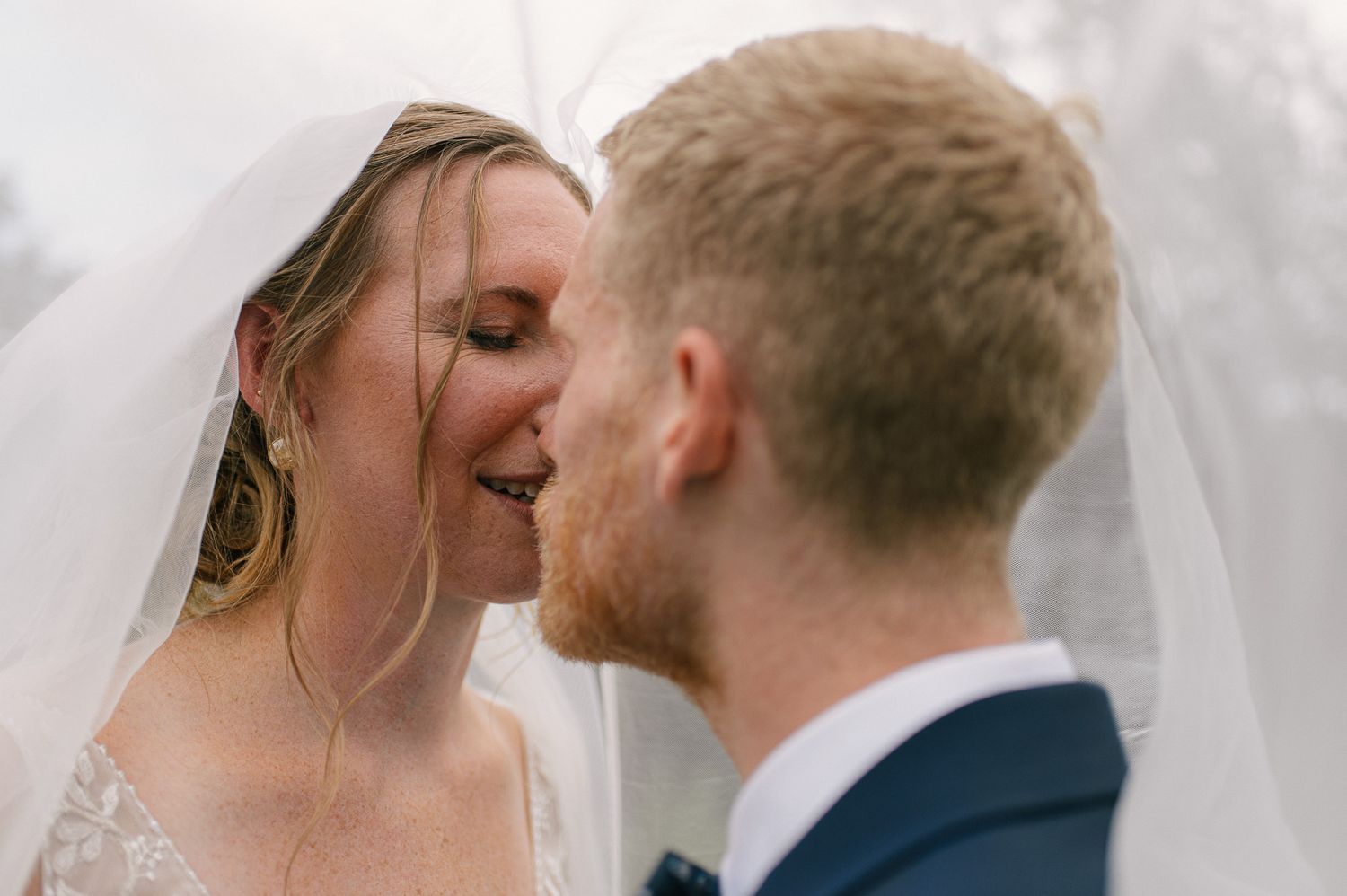 Close-up shot of a tender wedding moment against a light background.