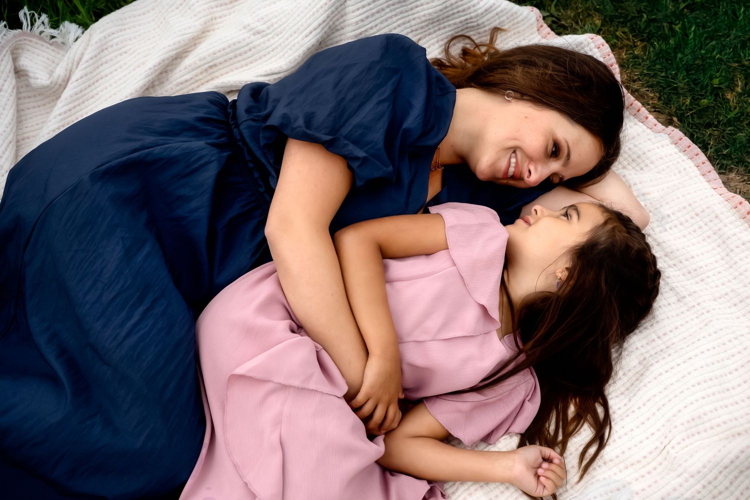 Sweet embrace captured on white blanket in garden setting.