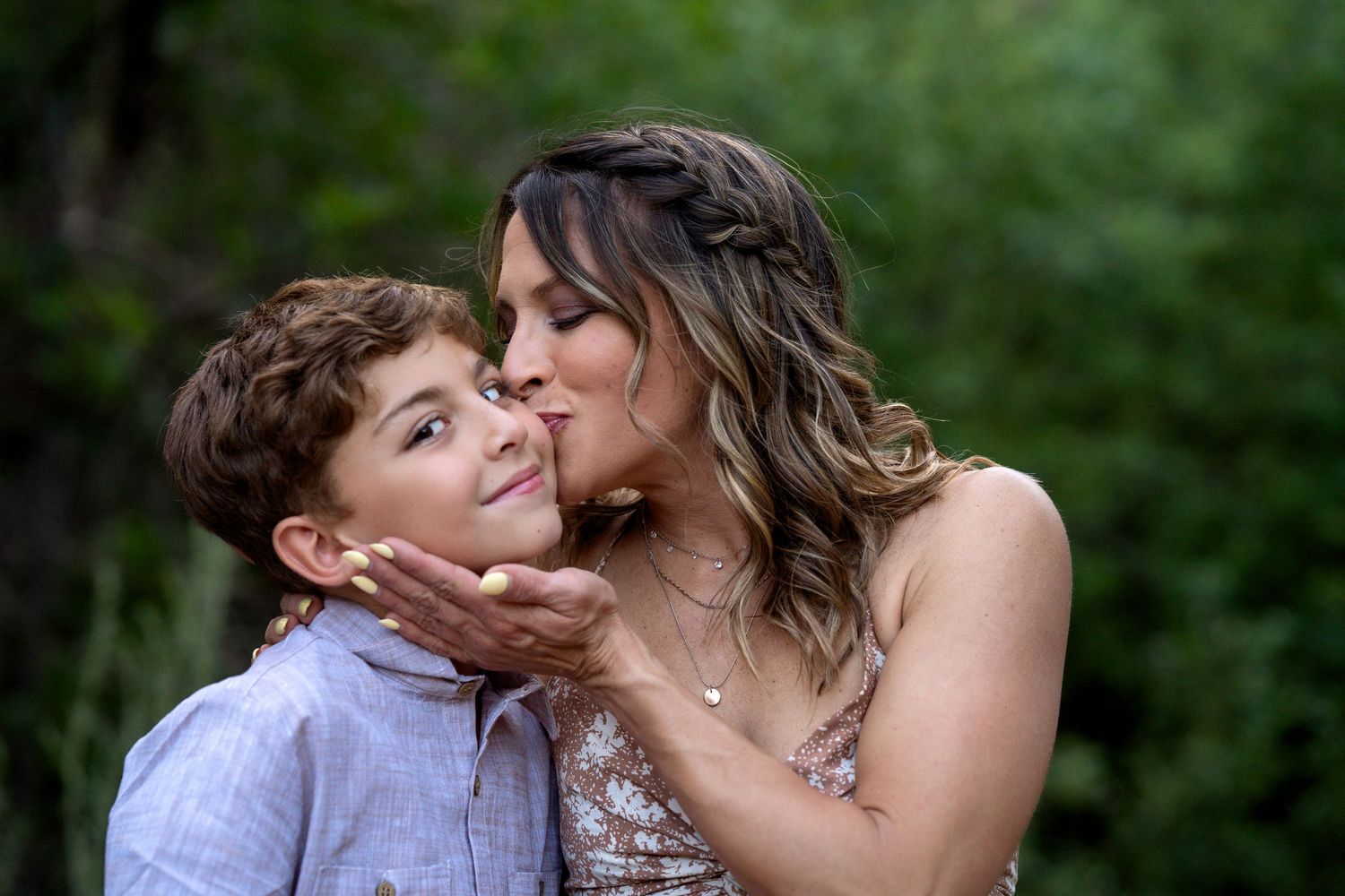 An intimate moment of affection captured between parent and child in a garden setting.