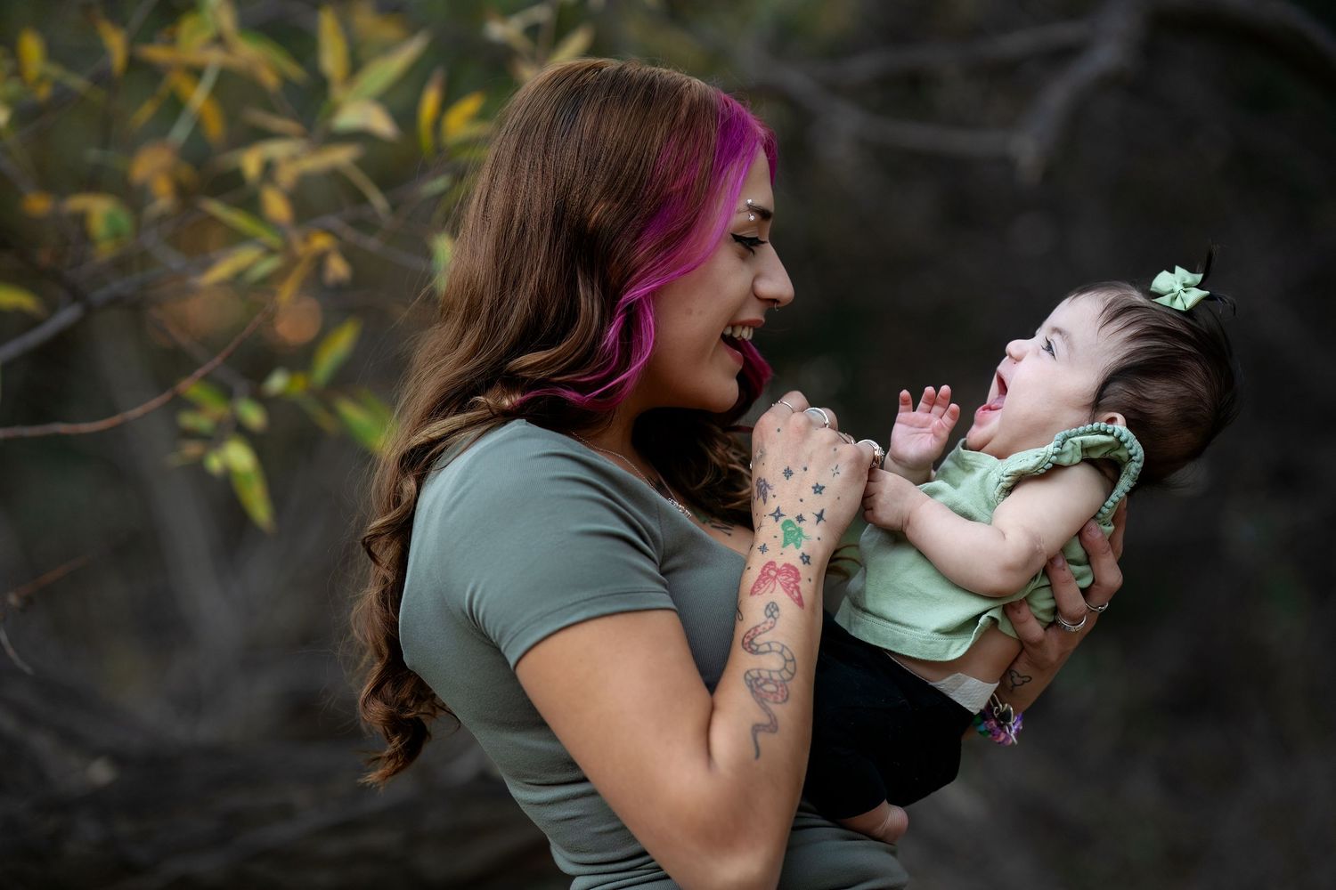 A candid moment of joy and laughter between a parent and baby outdoors.