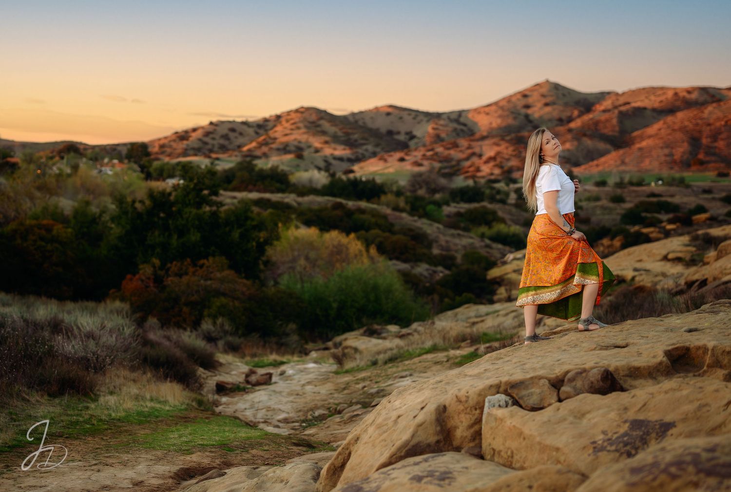 Scenic desert landscape photography with rock formations and mountains at golden hour.