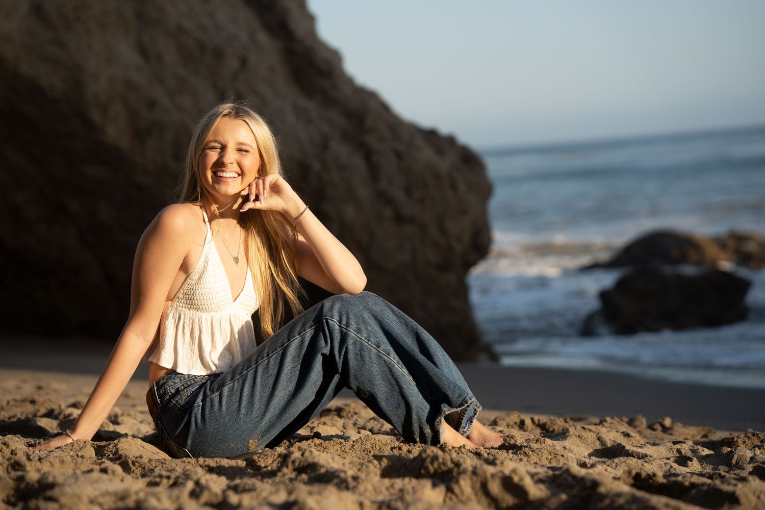 Relaxed beach portrait session with coastal rocks and ocean waves.