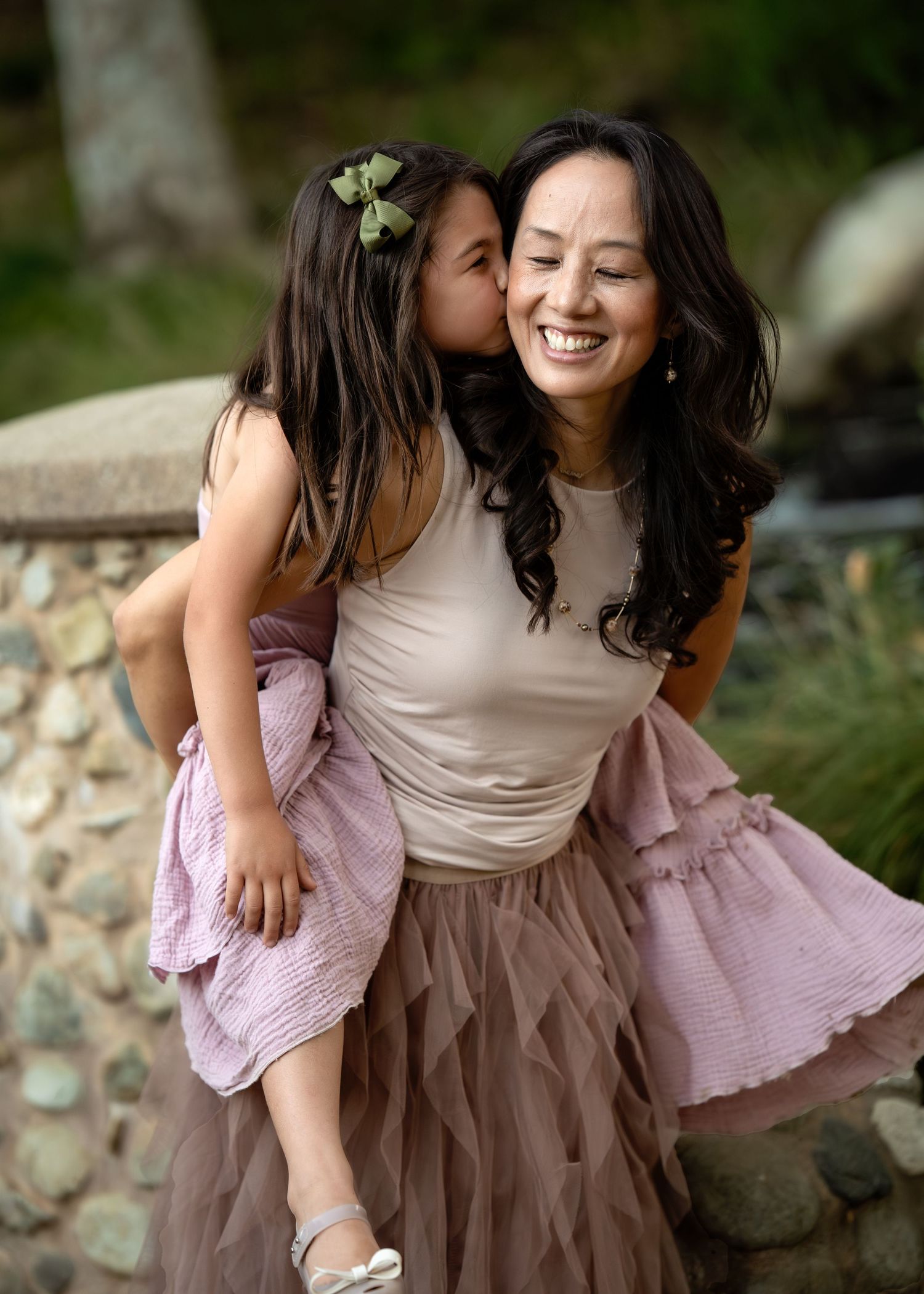 A sweet candid moment of affection between parent and child outdoors.