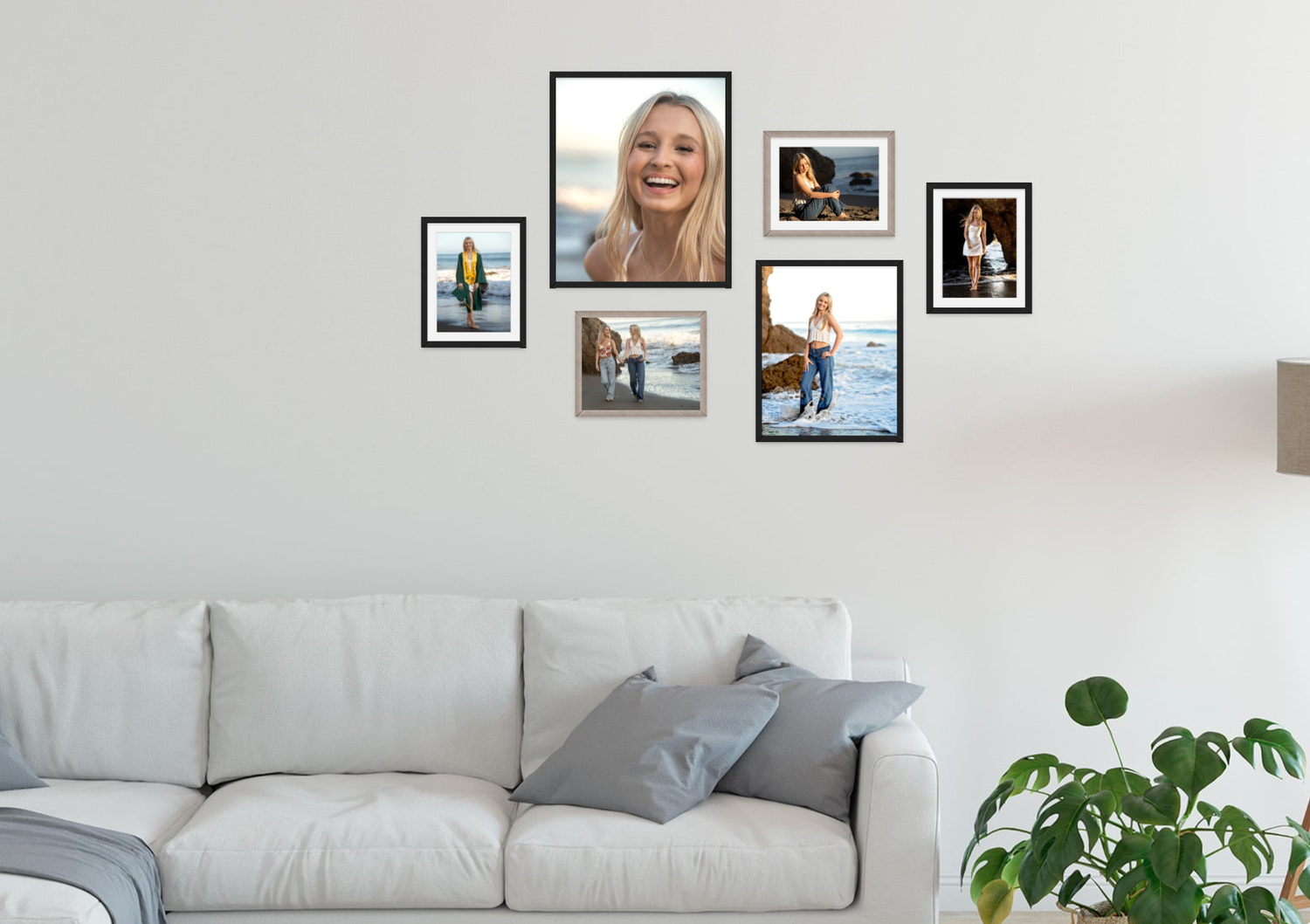Gallery wall display of framed photos above gray sofa in modern living room.