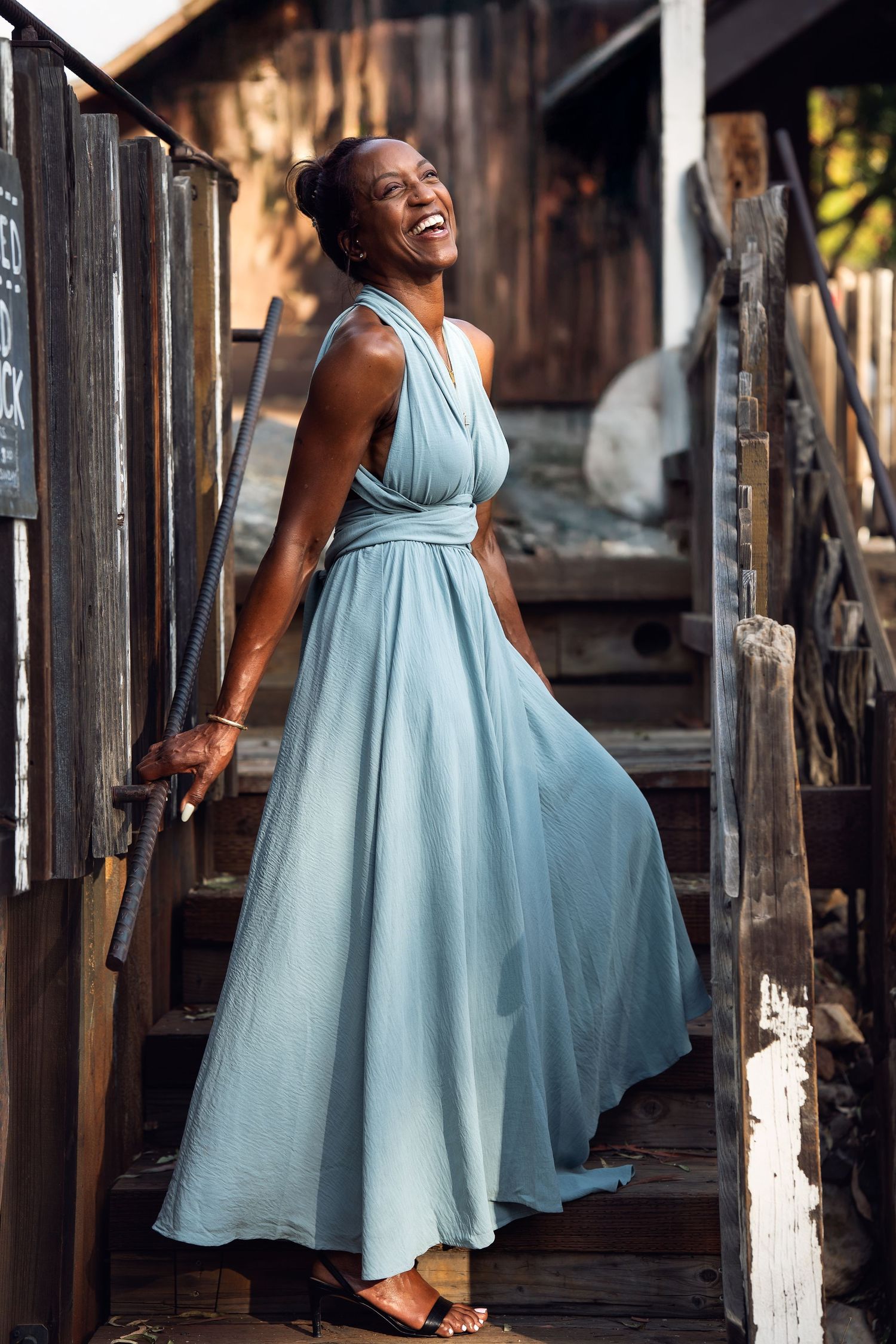 A flowing powder blue dress twirls gracefully in a series of shots against a rustic wooden setting.