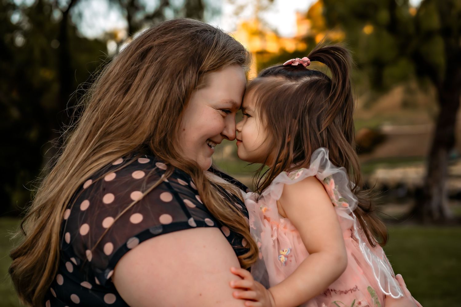 Intimate moment shared between parent and child outdoors at sunset.