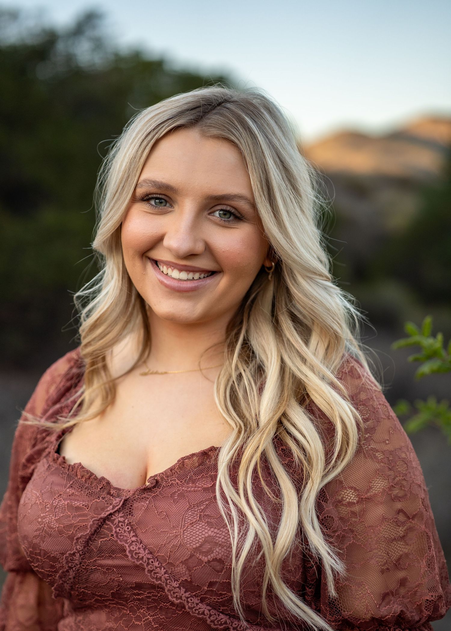 Outdoor portrait series featuring burgundy lace dress and natural lighting.