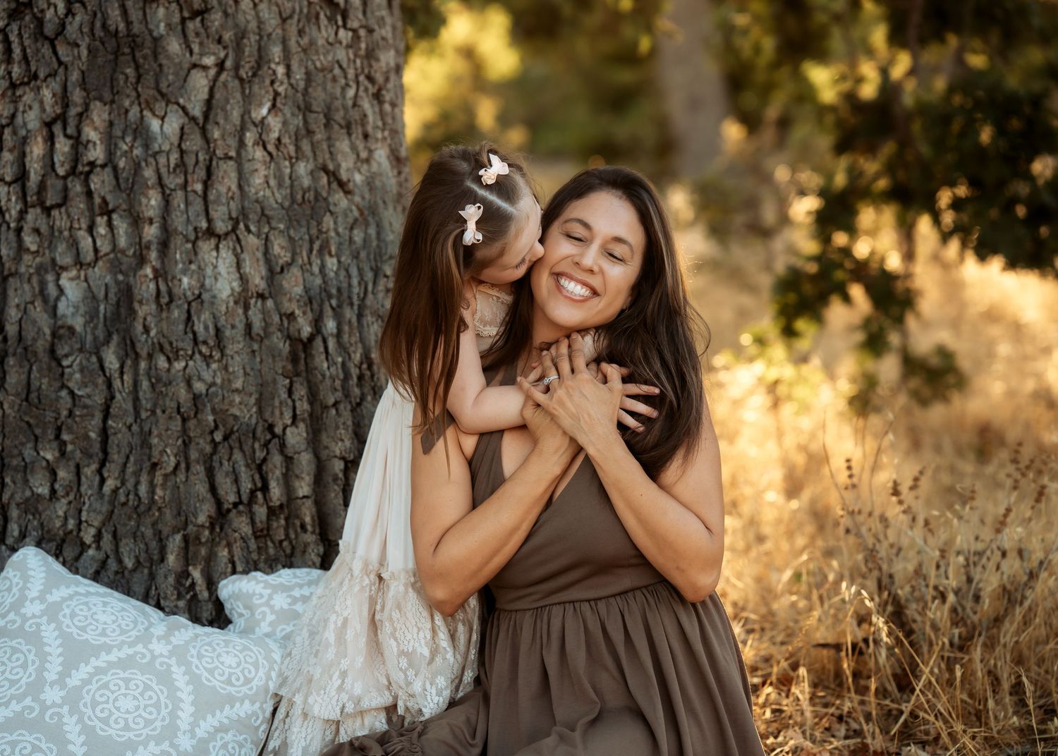 Intimate family portraits captured at sunset with golden backlighting through trees.