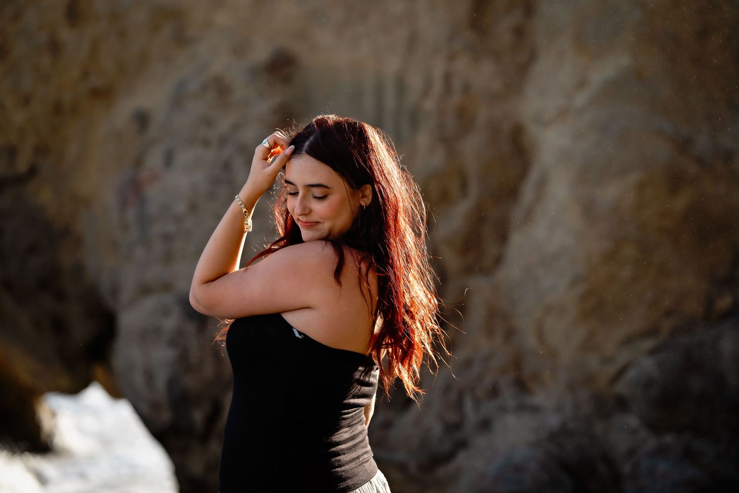 Artistic portrait session against textured stone wall backdrop.