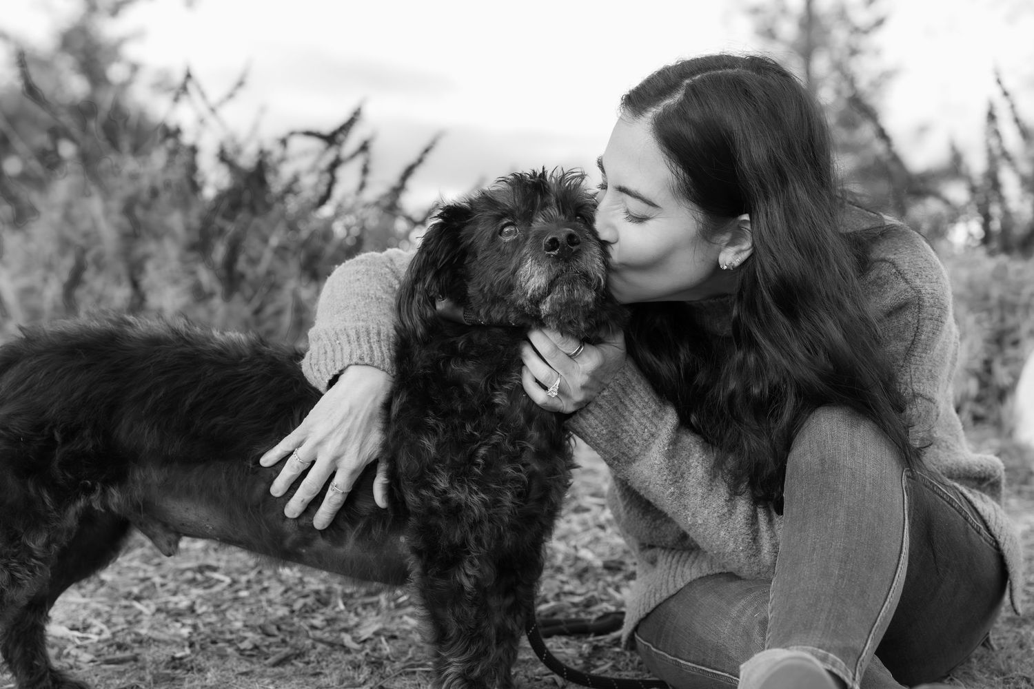 Dog and companion sharing affectionate moment outdoors.