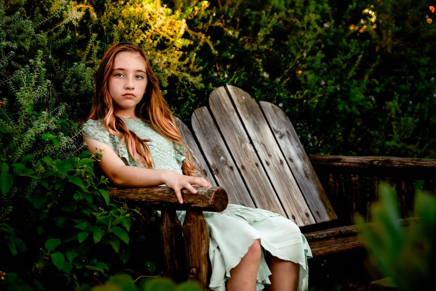 A wooden garden bench provides a perfect setting for summer portrait photography.
