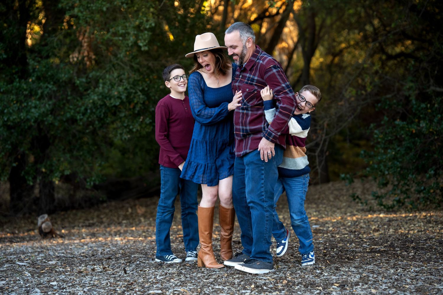 Family group huddled together wearing coordinated blue outfits in autumn setting.
