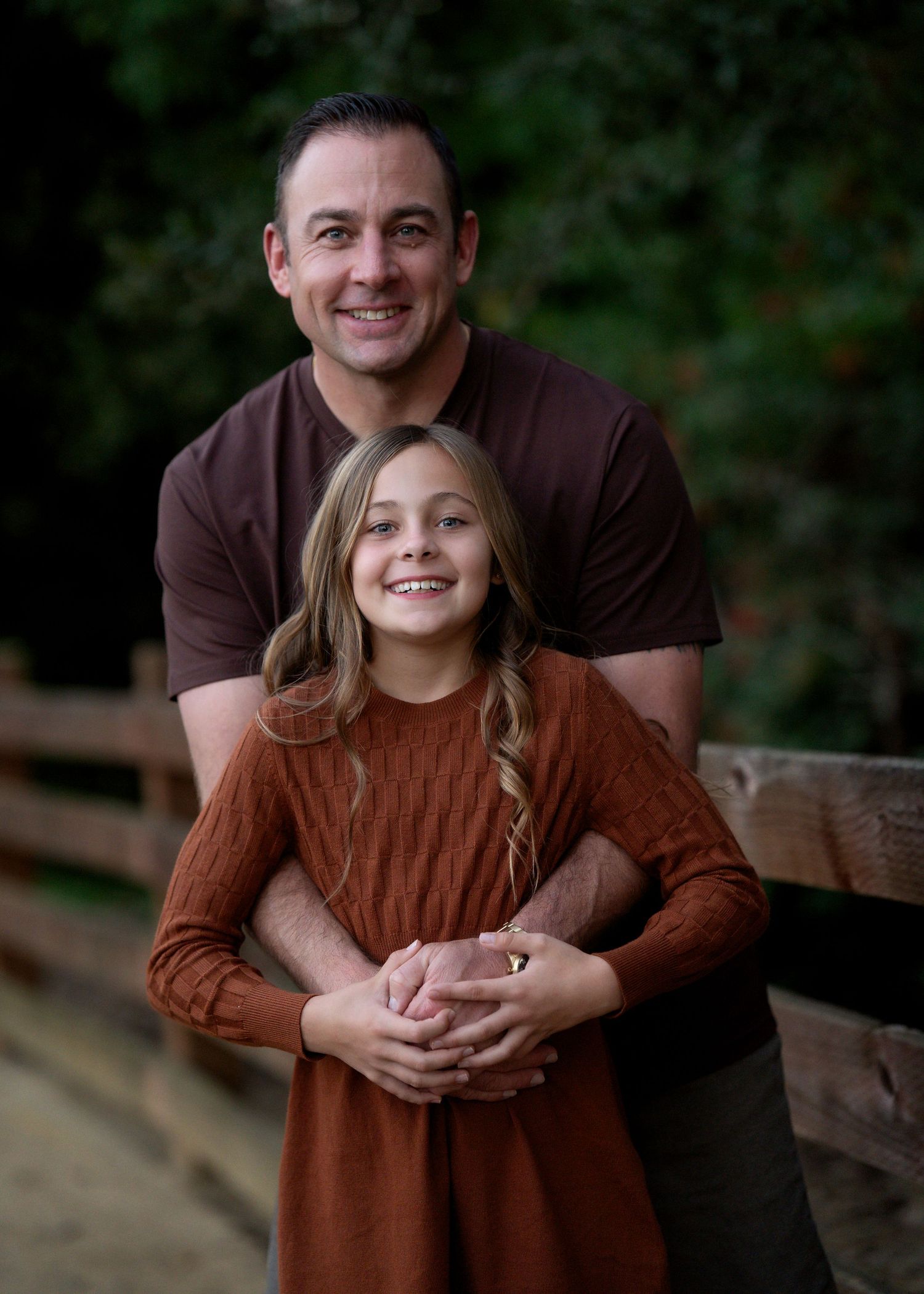 A heartwarming moment is captured between two people on a wooden bridge.