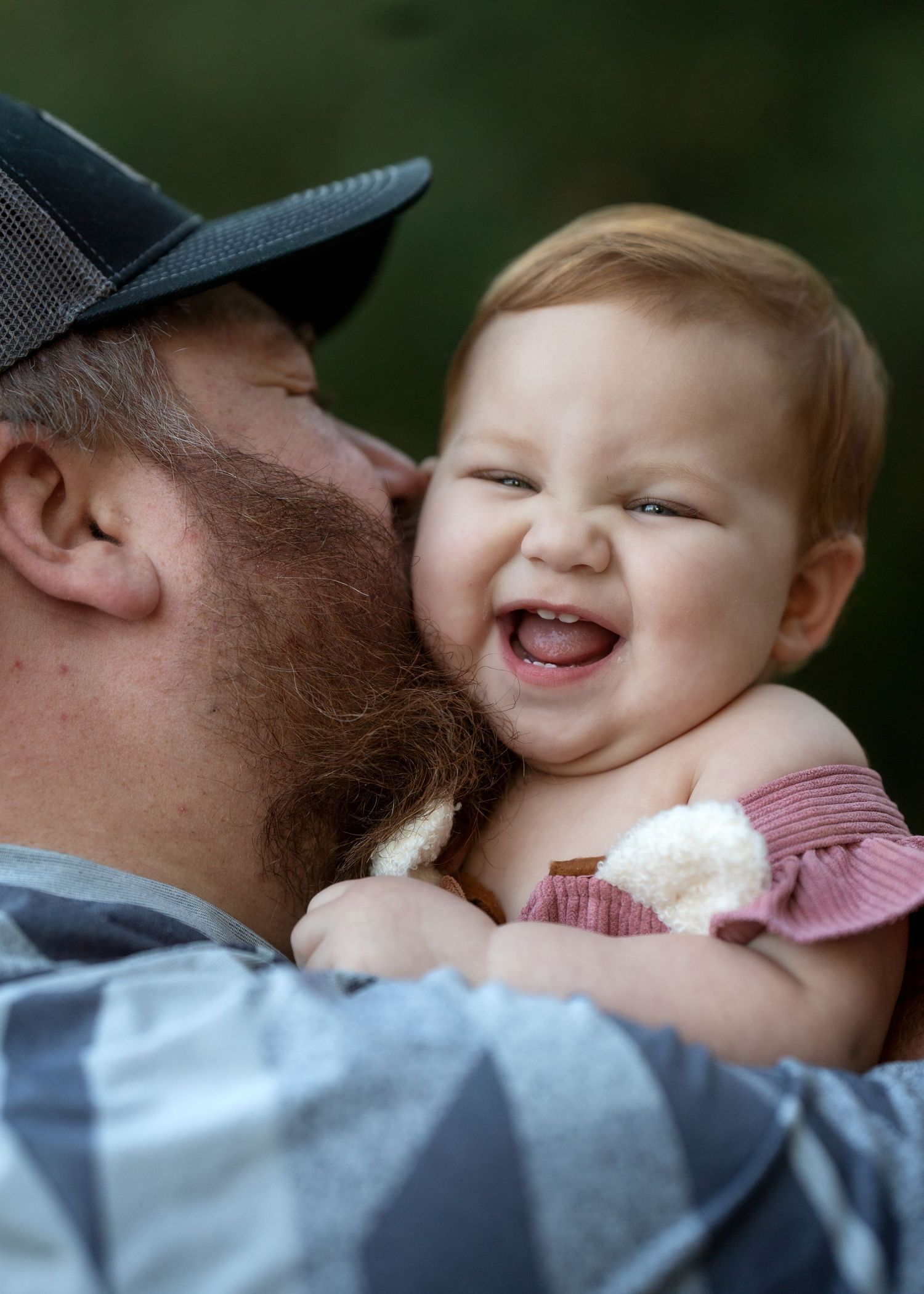 Joyful moments captured between parent and baby during outdoor photo session.