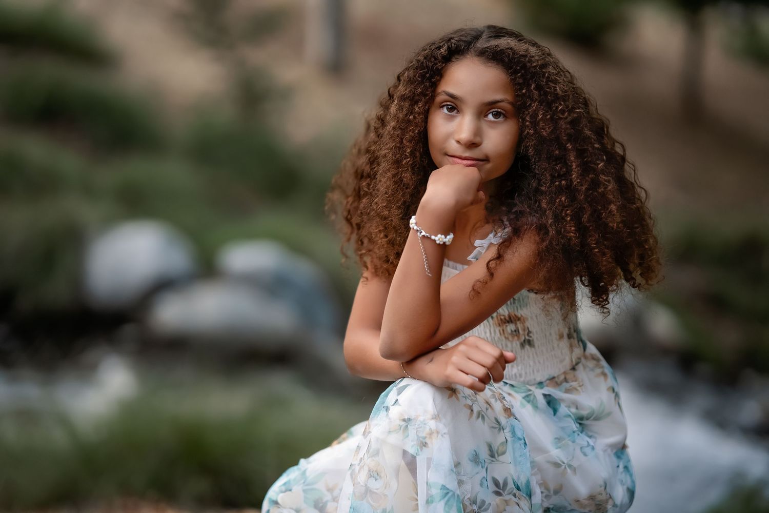 Beautiful floral dress portrait captured outdoors with soft natural lighting and greenery.