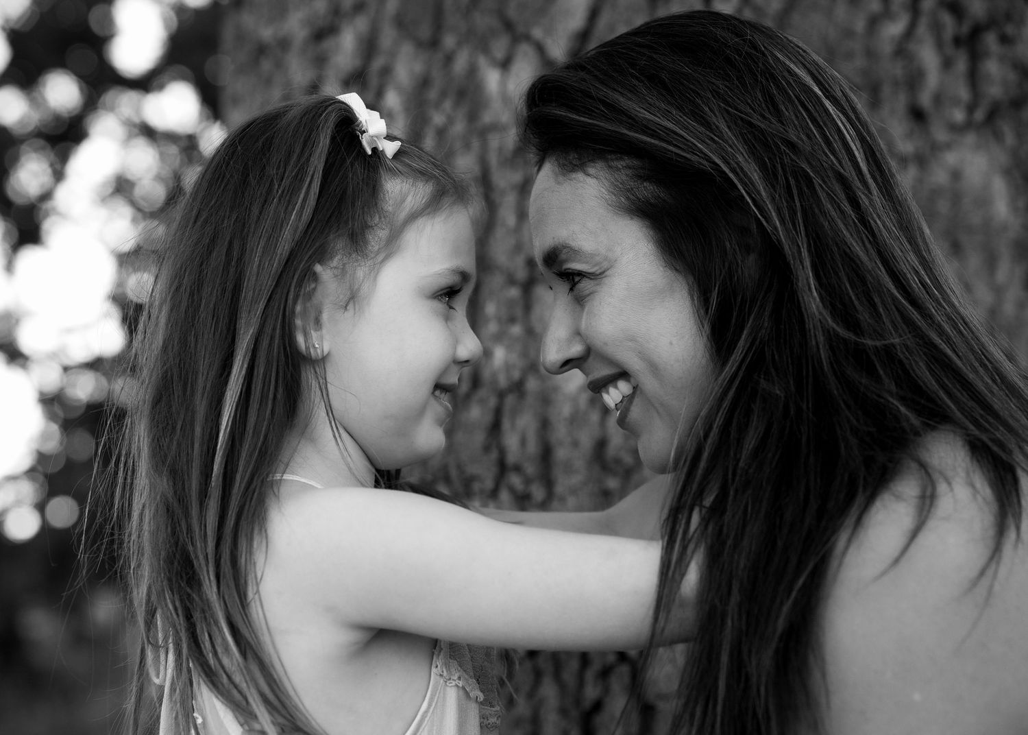 A tender black and white portrait capturing an intimate moment between parent and child.