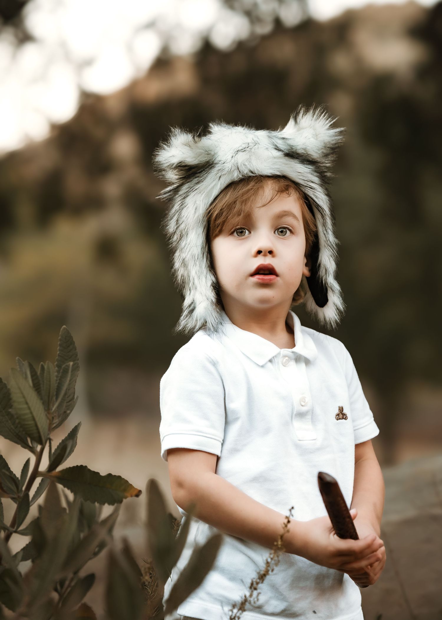 Series of playful moments wearing white outfit and furry winter hat in nature.