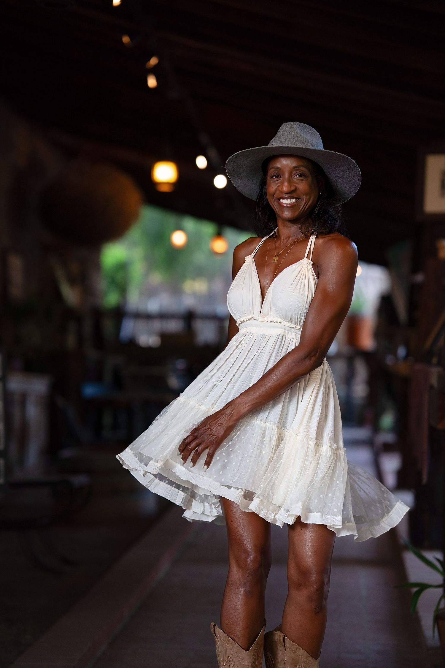 A flowing white summer dress twirls gracefully in a series of movement shots against a dark indoor background.