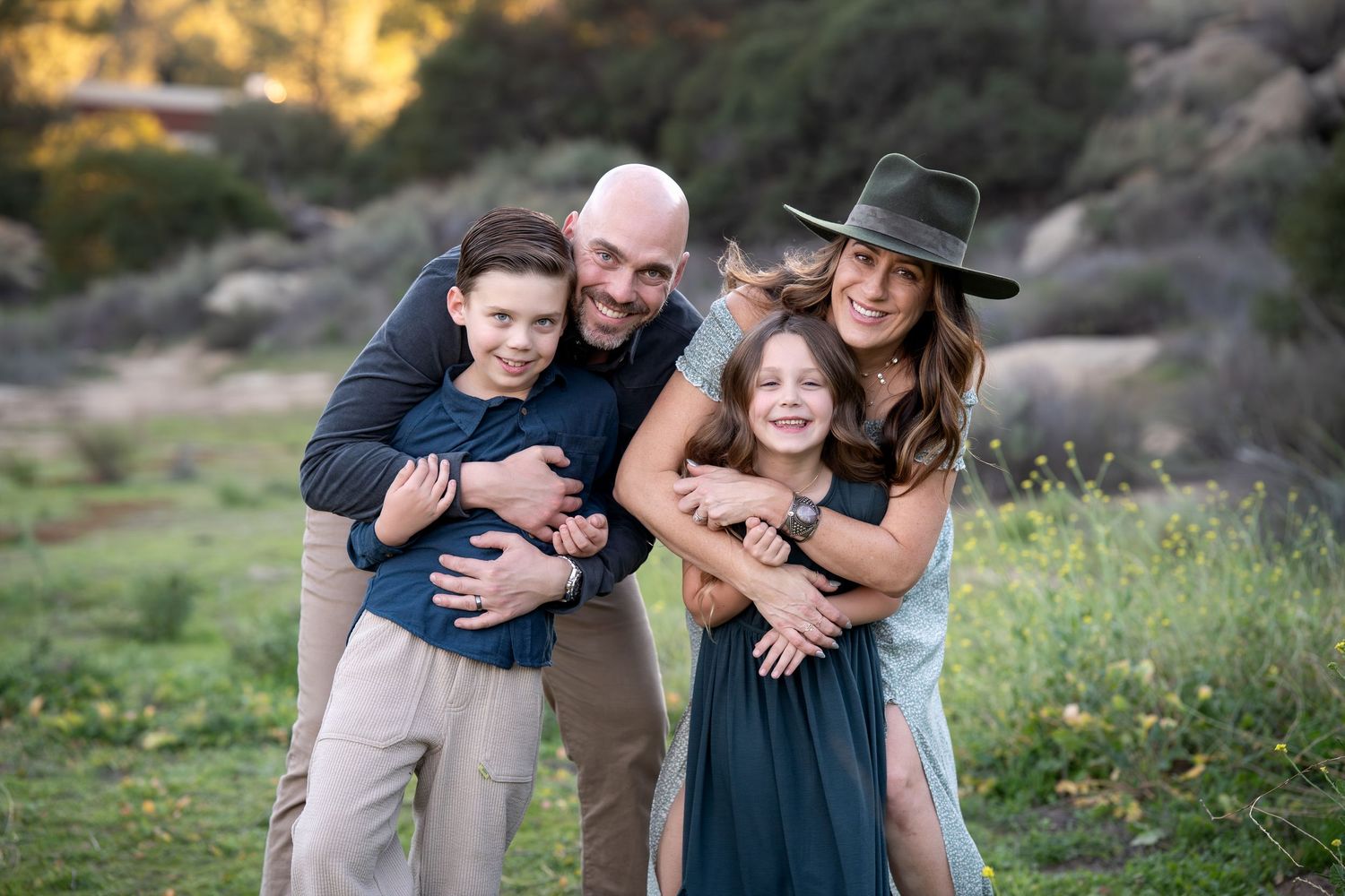 Candid family embrace captured during golden hour in a natural outdoor setting.