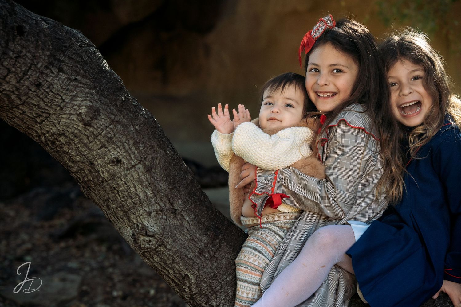 Joyful moment captured near a large tree trunk outdoors.