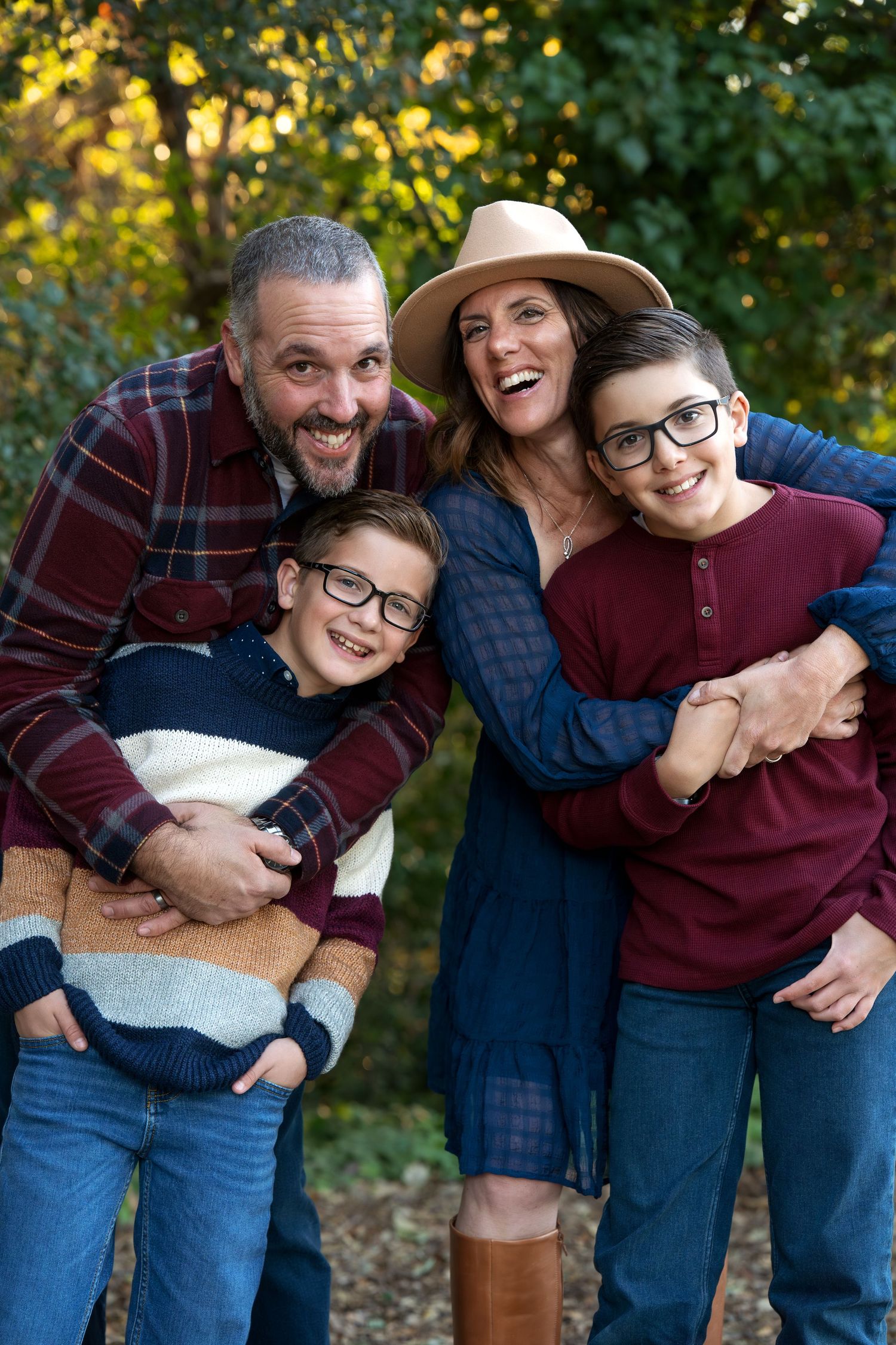 Joyful outdoor family portrait with casual fall clothing and warm autumn colors in the background.