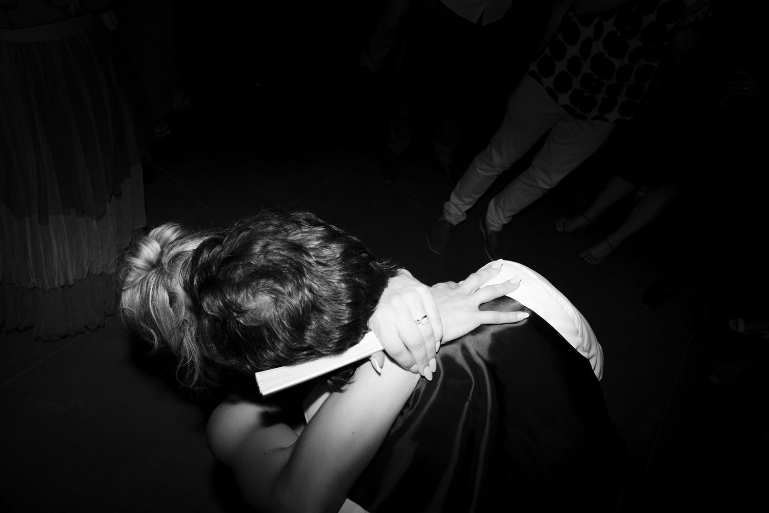 Black and white photo of wedding guest bowing low on the dance floor.