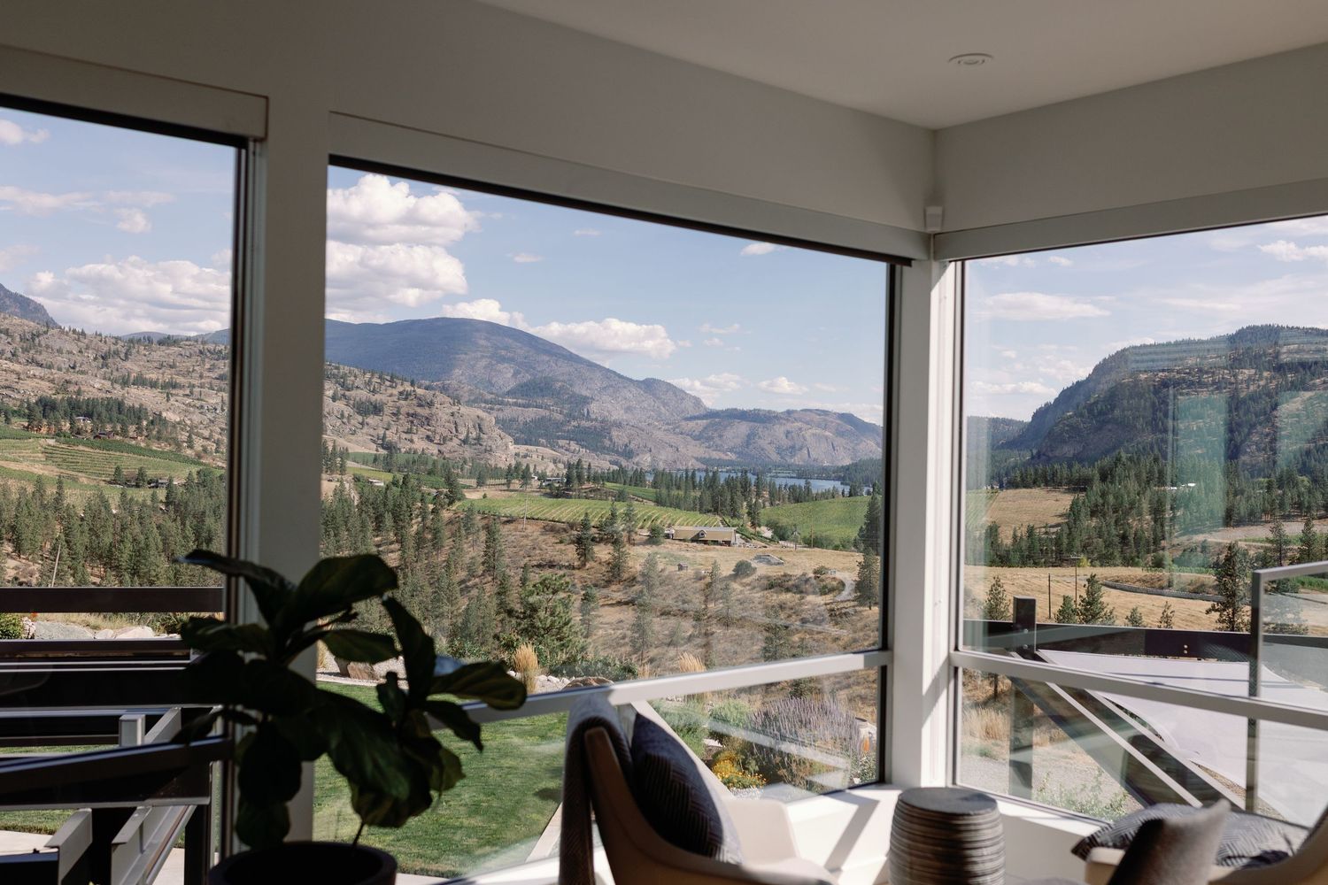 Modern interior with floor-to-ceiling windows showcasing stunning mountain and valley views.