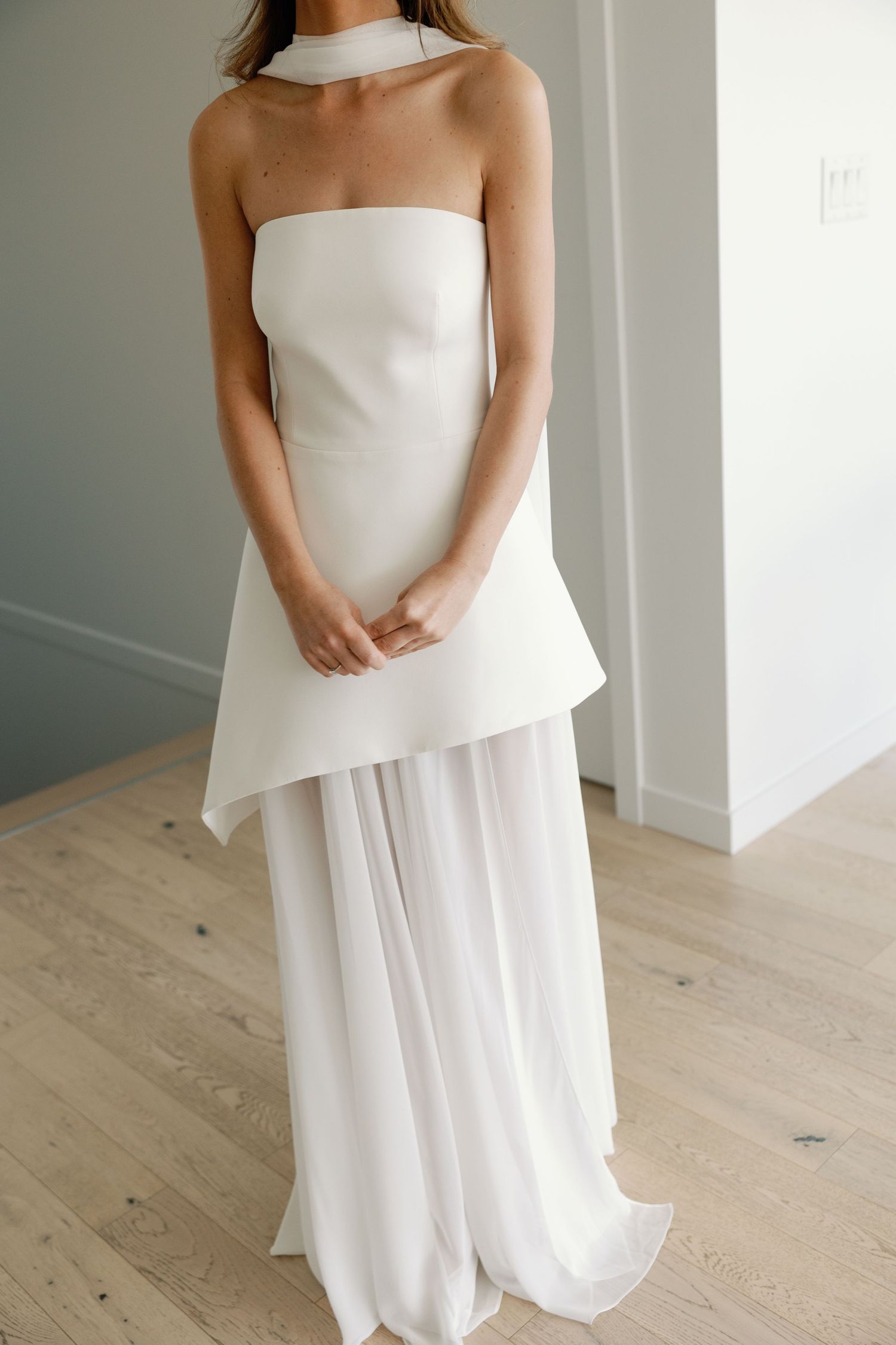 Minimalist bridal look featuring a structured white halter top with elegant flowing chiffon wide-leg pants.