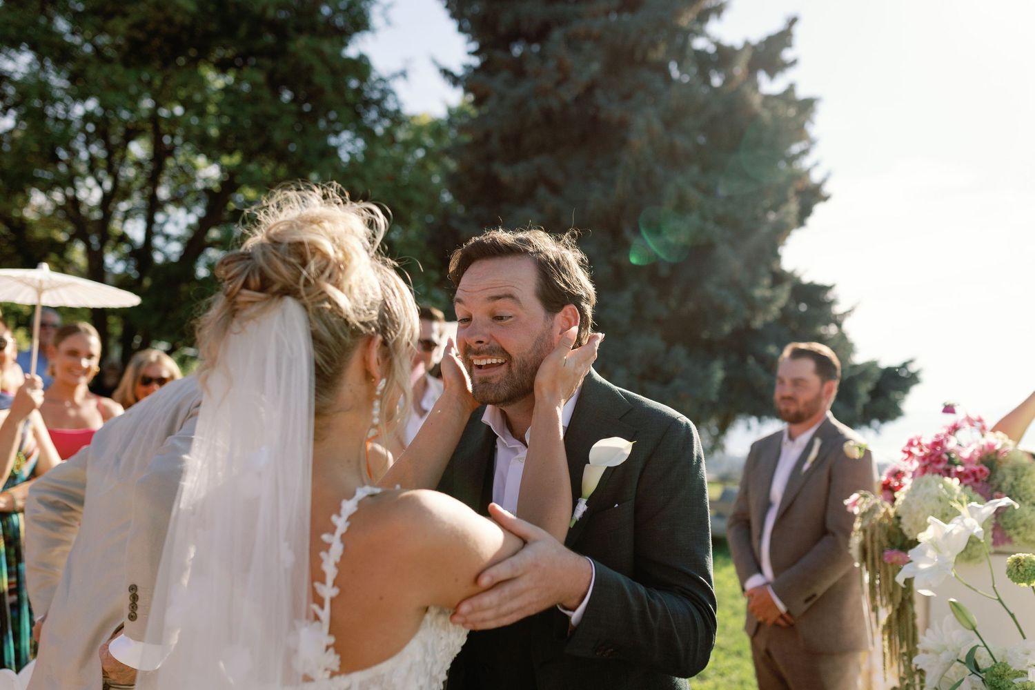 Groom tenderly cupping bride's face at the altar during an emotional outdoor wedding ceremony.