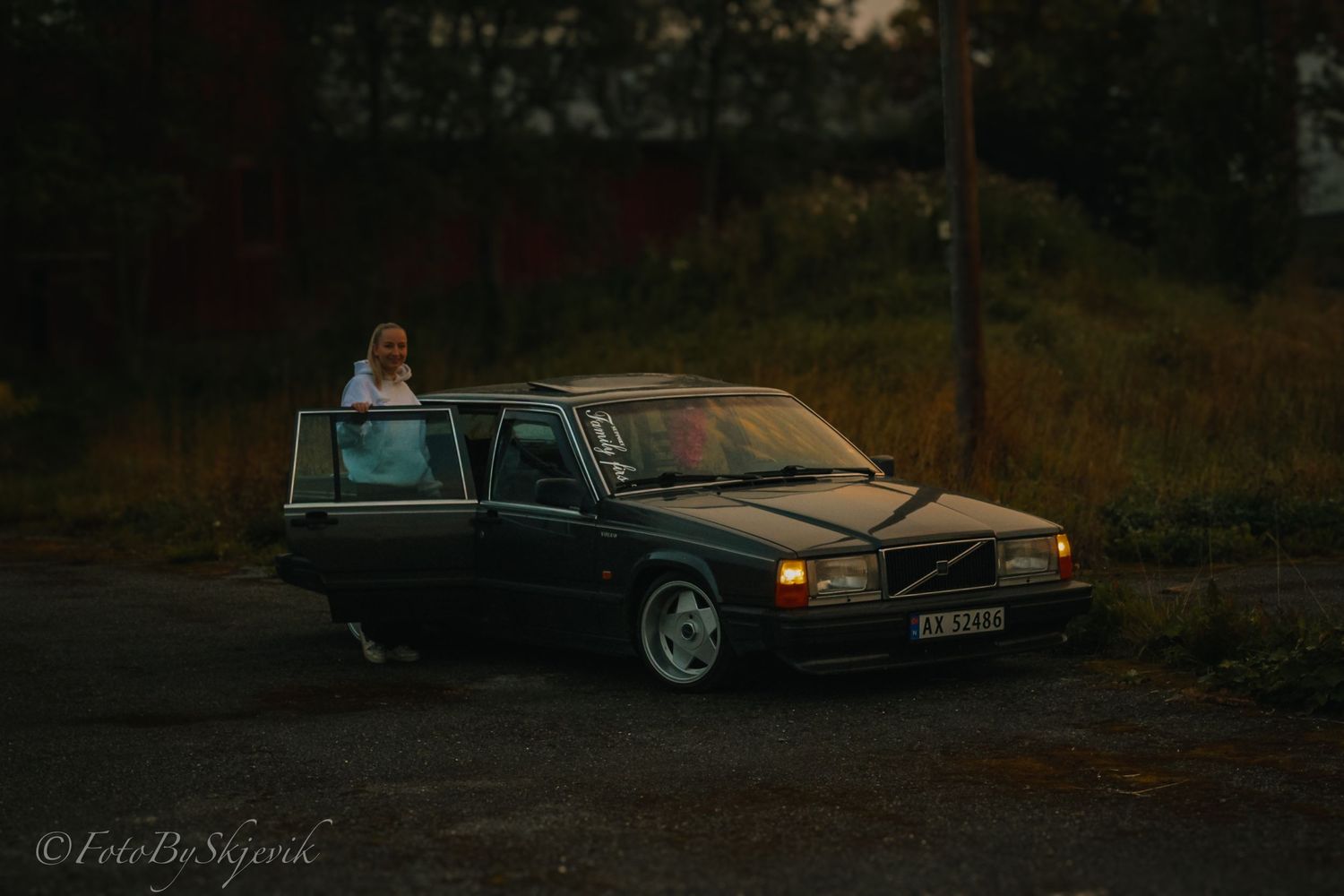 A classic Volvo sedan photographed during sunset in a moody outdoor setting.
