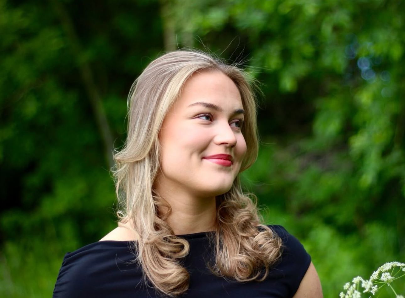 Spring flowers and greenery create a natural outdoor portrait backdrop.