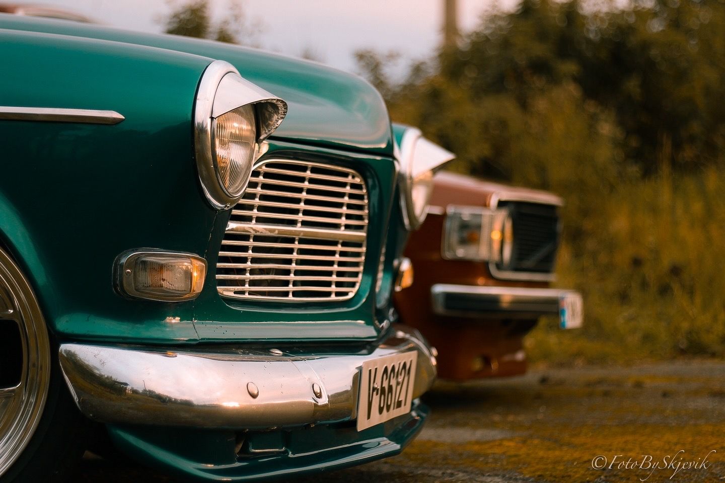 Close-up of classic green car front grille and chrome details.