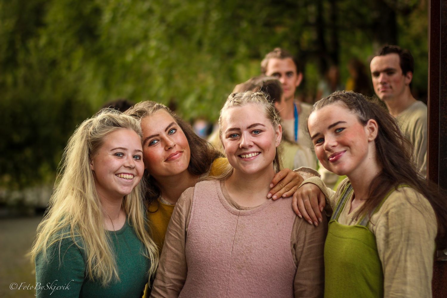 Group gathered outdoors wearing casual clothing in natural setting.