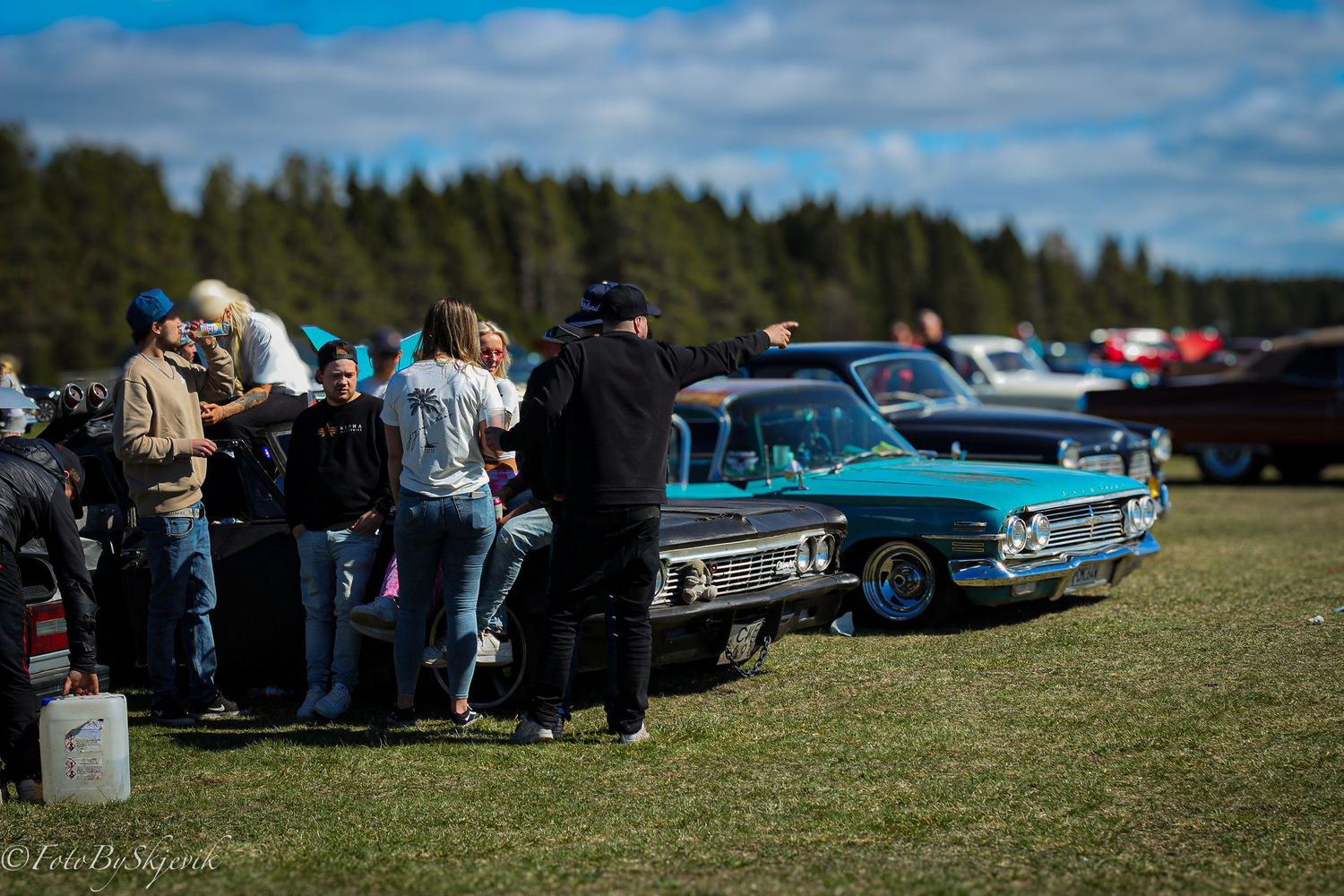 Panoramic view of classic cars and spectators gathered at an outdoor auto show.
