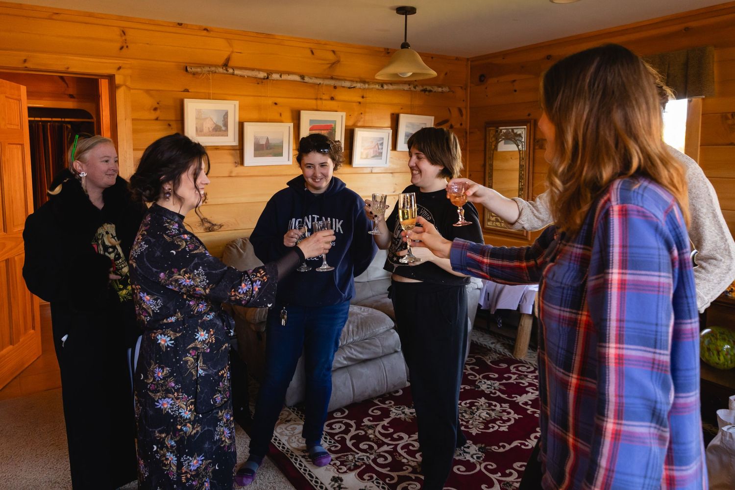 A group of people gathered in a rustic cabin-style room with wood paneled walls during a social event.