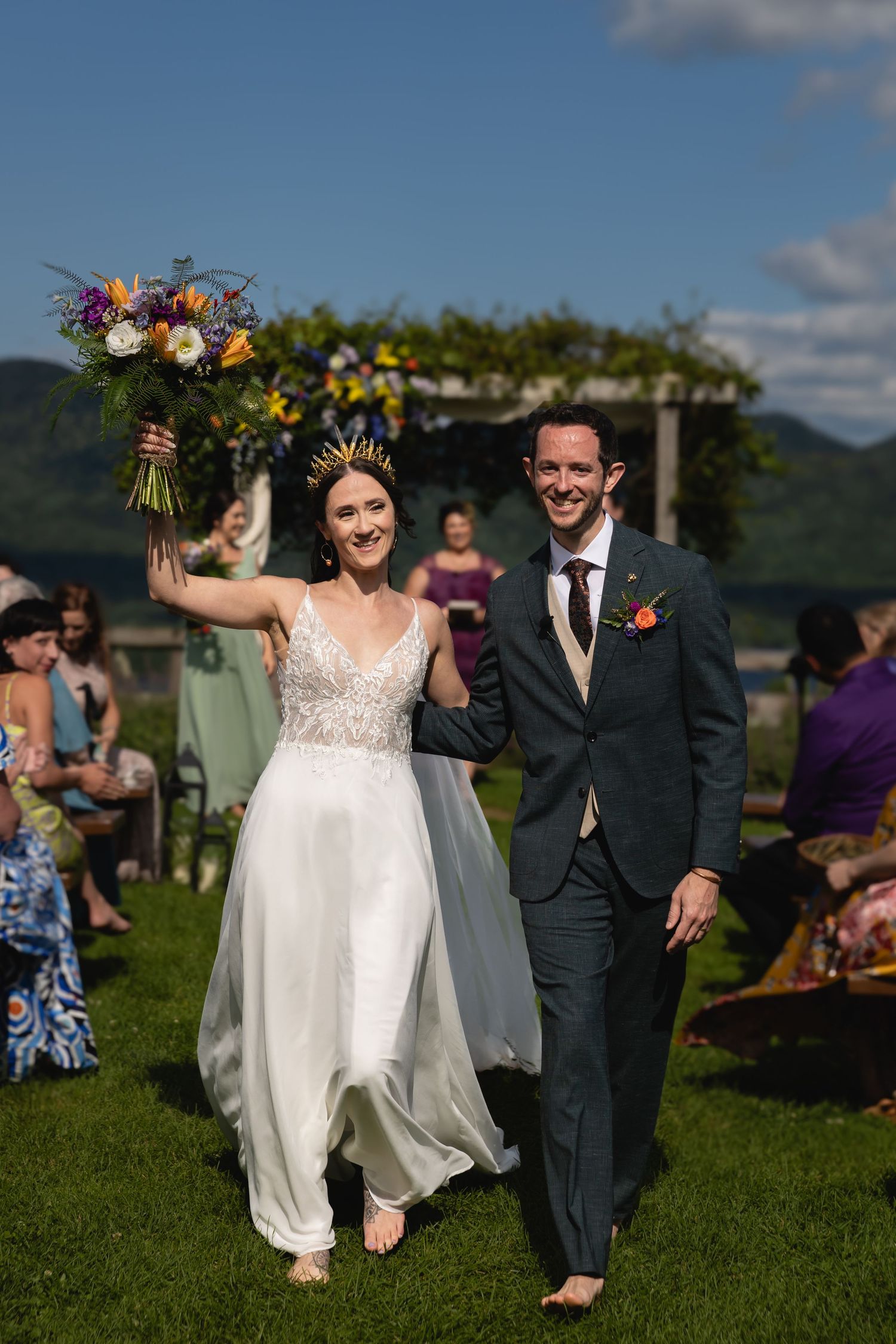 Newlyweds walk down the aisle together at their outdoor mountain wedding ceremony.