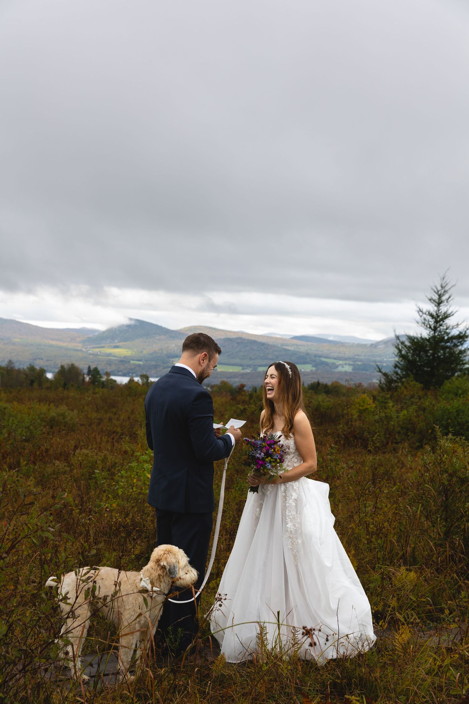 A couple exchanges vows during their outdoor mountain wedding ceremony with their dog present.