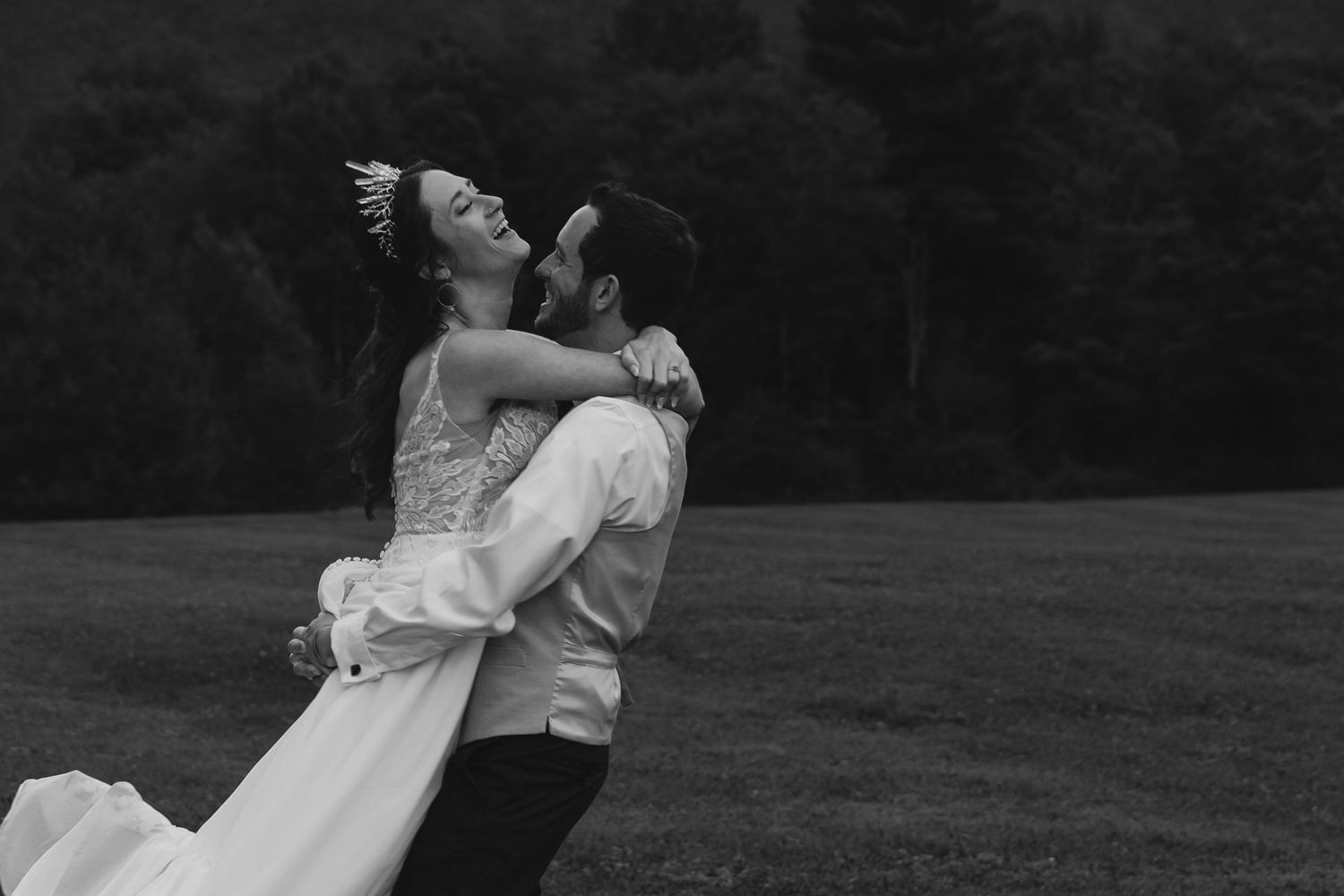 Black and white romantic lift pose in outdoor wedding portrait.