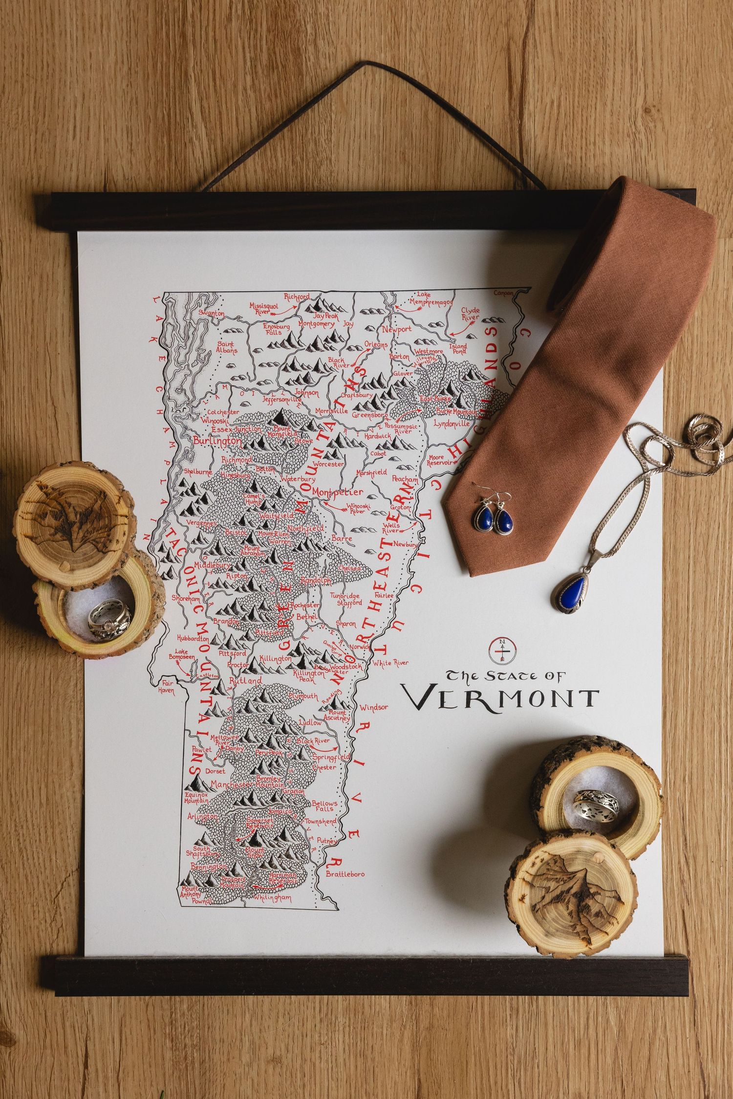 A hand-drawn map of Vermont displayed with wooden accents and jewelry decorations.