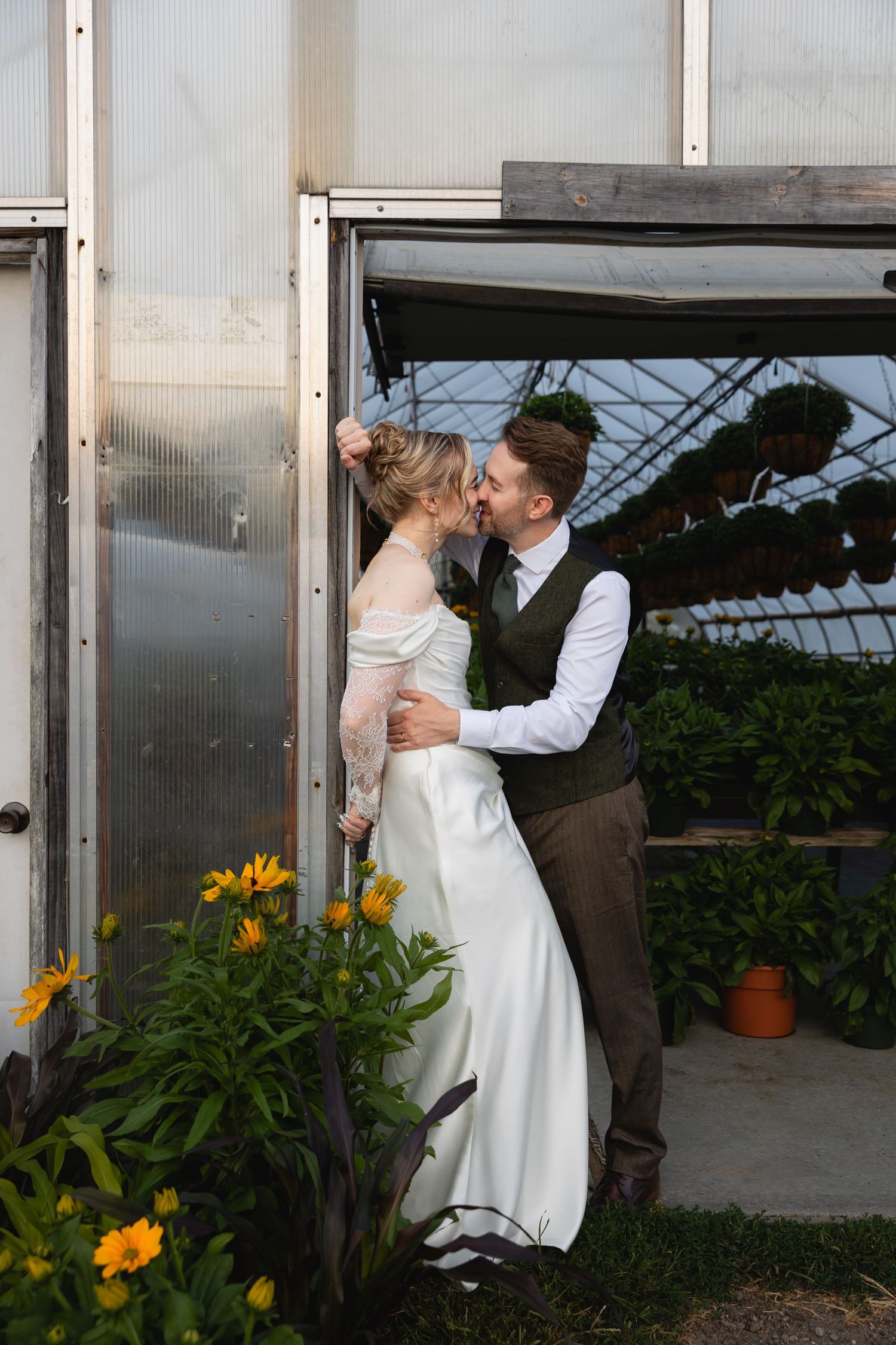 A romantic dance sequence of a couple in formal wedding attire inside a greenhouse with yellow flowers in the background.